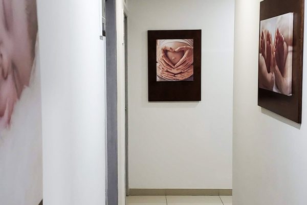 Instalaciones de la clínica de fertilidad Concibo Reproductive Clinic, un pasillo donde se exponen imágenes de maternidad y fertilidad en las paredes.