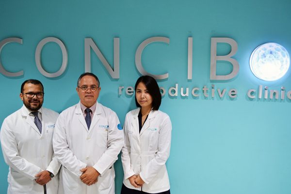 El Dr. Oscar Valle Virgen, junto al Dr. Edgar Medina y la Dra. Lee posando junto al logo de la clínica de reproducción asistida Concibo Reproductive Clinic, en sus instalaciones de Tijuana.