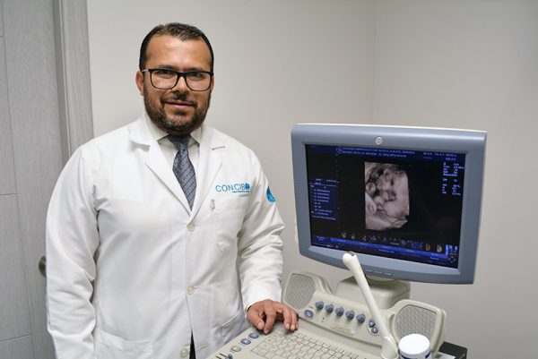 Dr. Edgar Medina posing with ultrasound equipment at Concibo Reproductive Clinic's facilities.